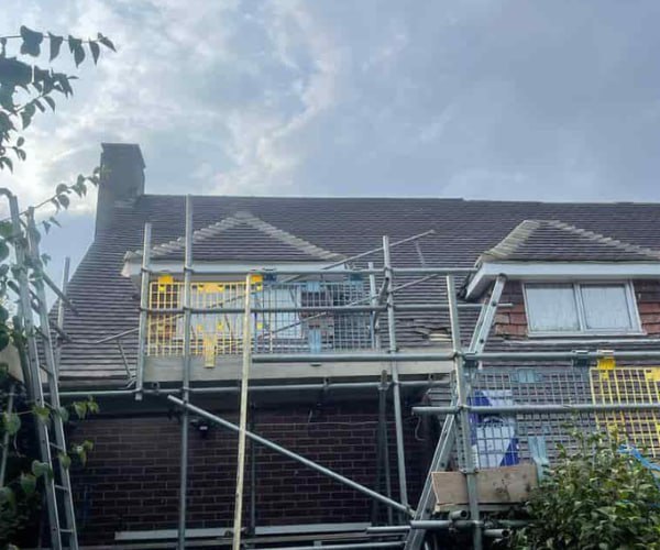 This is a photo of a roof with two dormers that is having some damaged tiles replaced. Works carried out by NRS Roofing Thrapston